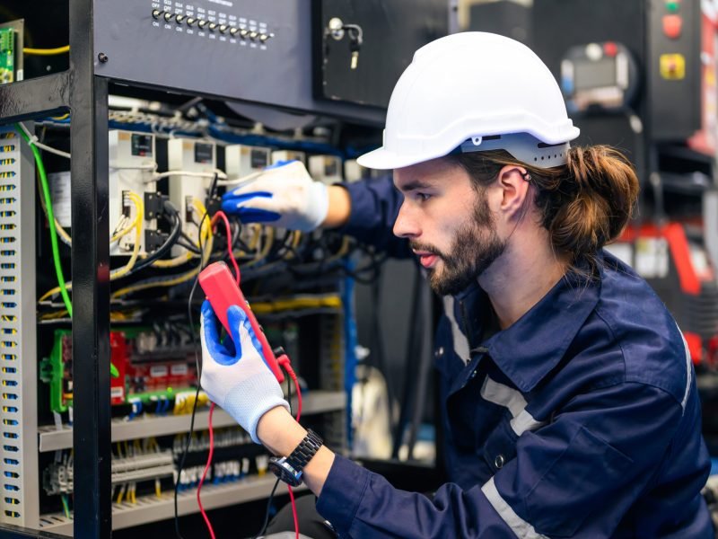 Technician engineer holding robot controller checking and repairing automatic robotic machine at industrial factory, Worker working with robotic arm system in factory